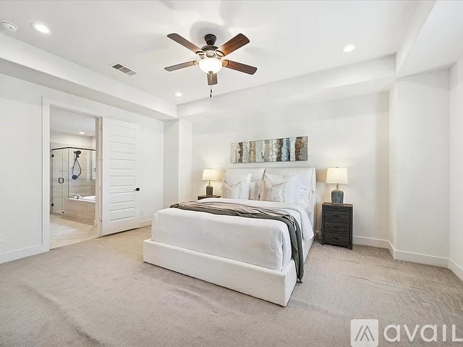 A bedroom with a large bed and a ceiling fan.