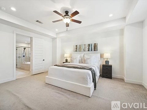 A bedroom with a large bed and a ceiling fan.