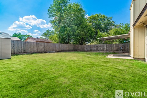 A backyard with a wooden fence and a shed.