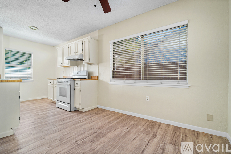 A kitchen with a white oven and wooden floors.