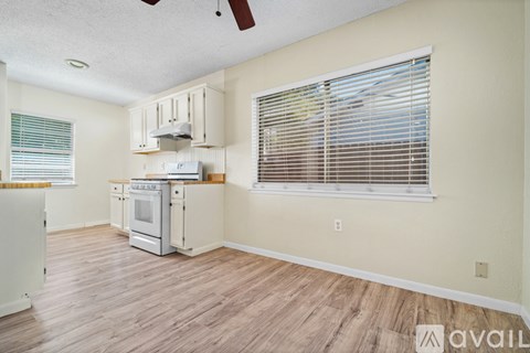 A kitchen with a white oven and wooden floors.