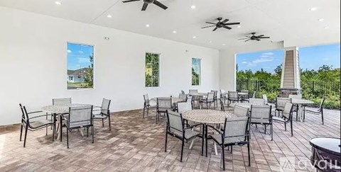 A spacious outdoor dining area with multiple tables and chairs.