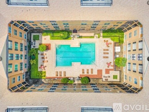 An aerial view of a courtyard with a pool surrounded by buildings.