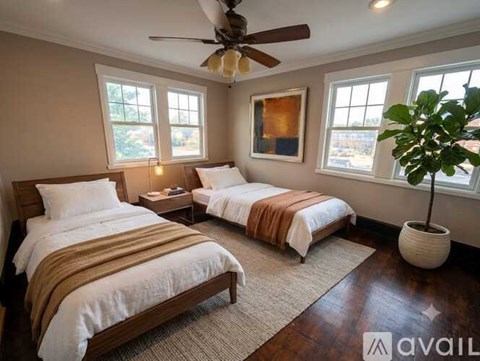 A bedroom with two beds and a ceiling fan.