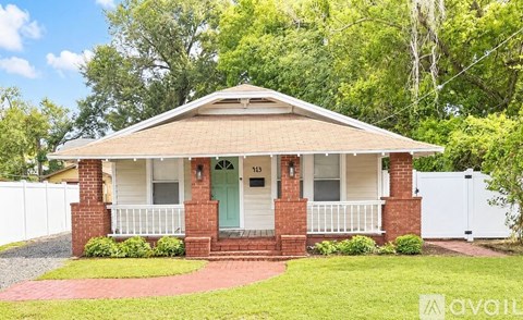 A house with a green door and a white fence in front.
