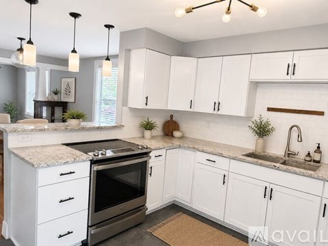 A kitchen with white cabinets and a granite countertop.