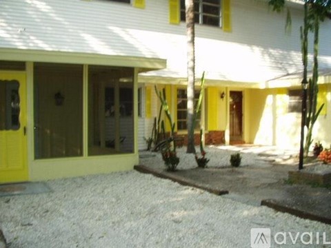 A white house with yellow trim and a yellow door.