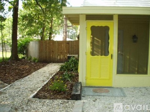 A yellow door is on the right side of a house.