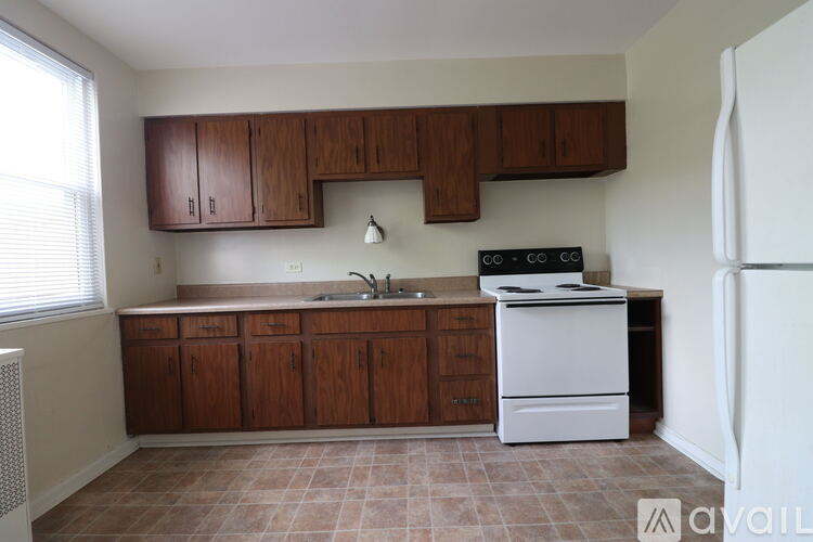 A kitchen with a white stove and wooden cabinets.