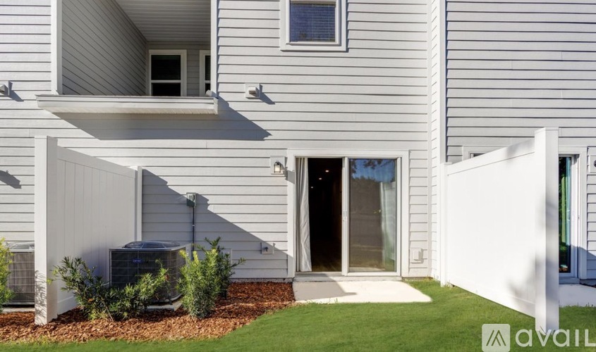 A modern house with a grey exterior and a white entrance.