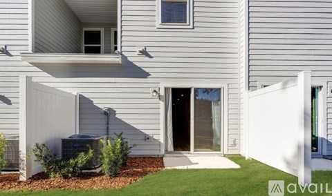 A modern house with a grey exterior and a white entrance.