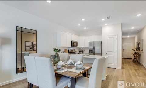 A dining area with a table set for two and a mirror on the wall.