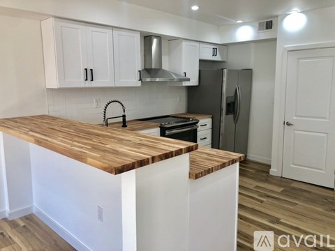 A kitchen with white cabinets and a wooden countertop.