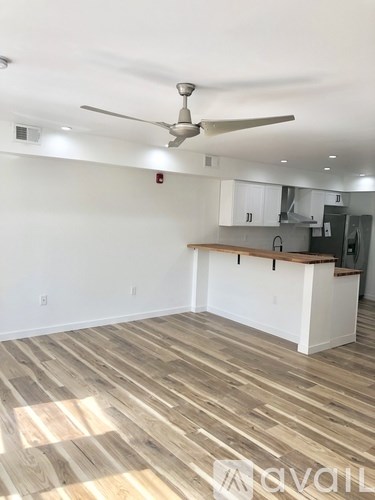 A room with a ceiling fan and wooden flooring.