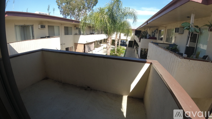 A balcony of a house with a view of other houses and trees.