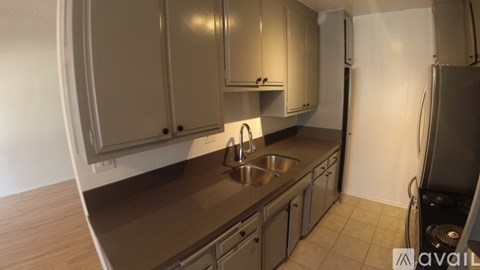 A kitchen with a sink and a refrigerator.