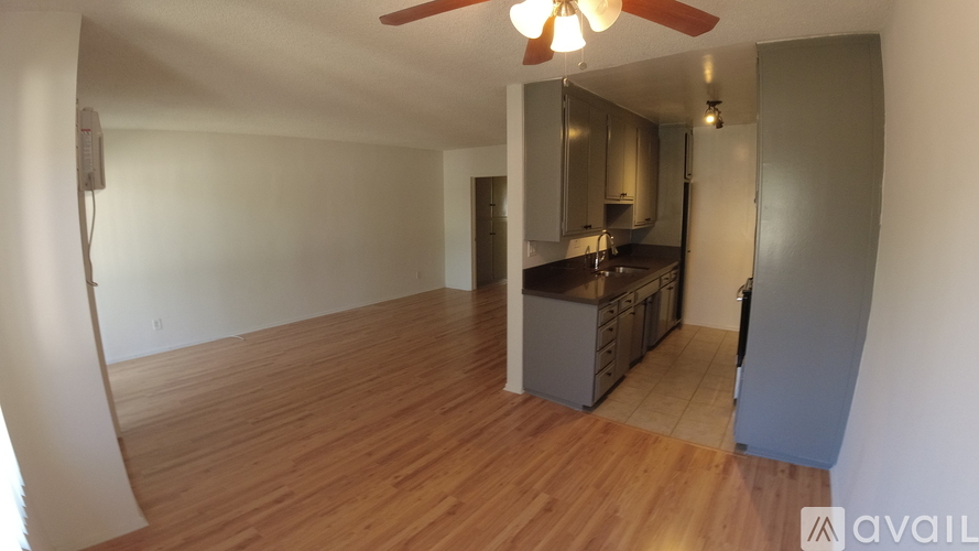 A room with wooden floors and a ceiling fan.