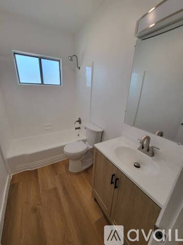 A bathroom with a toilet, sink, and mirror.