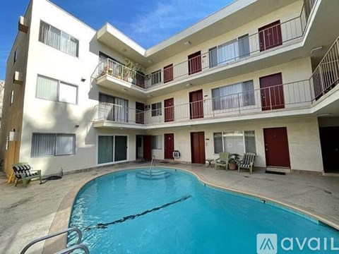A large swimming pool is in the middle of a courtyard surrounded by apartment buildings.