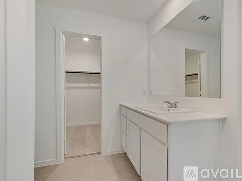 A white bathroom with a sink and mirror.