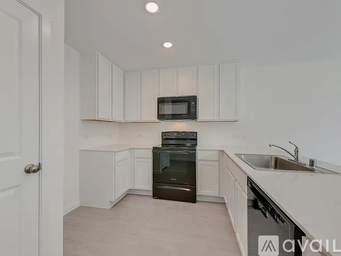 A kitchen with white cabinets and a black oven.