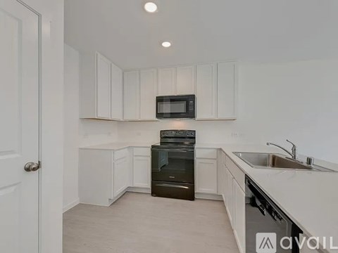 A kitchen with white cabinets and a black oven.