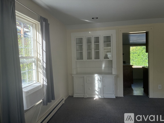 A room with a window, curtains, and a cabinet is available for rent.