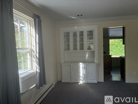 A room with a window, curtains, and a cabinet is available for rent.