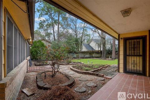 A patio area with a circular garden and a view of a backyard.