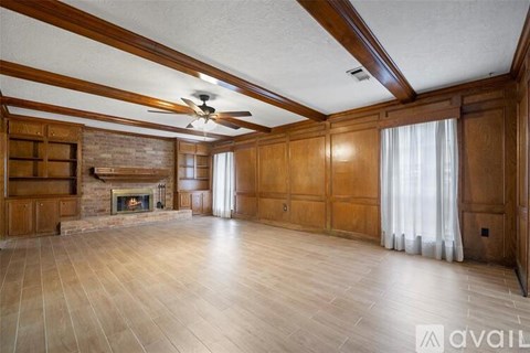 A spacious room with wooden walls and a fireplace.