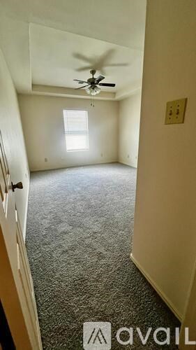 A room with a ceiling fan and a window.