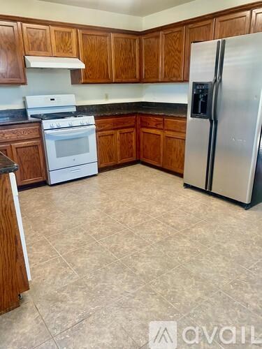 A kitchen with a white fridge and stove.