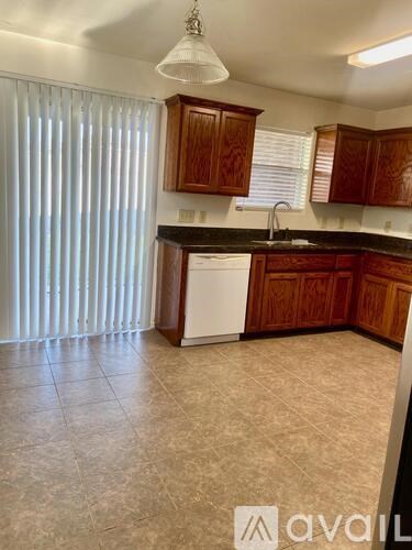 A kitchen with wooden cabinets and a white dishwasher.