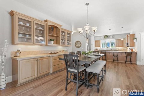 A kitchen with wooden cabinets and a dining table with chairs.
