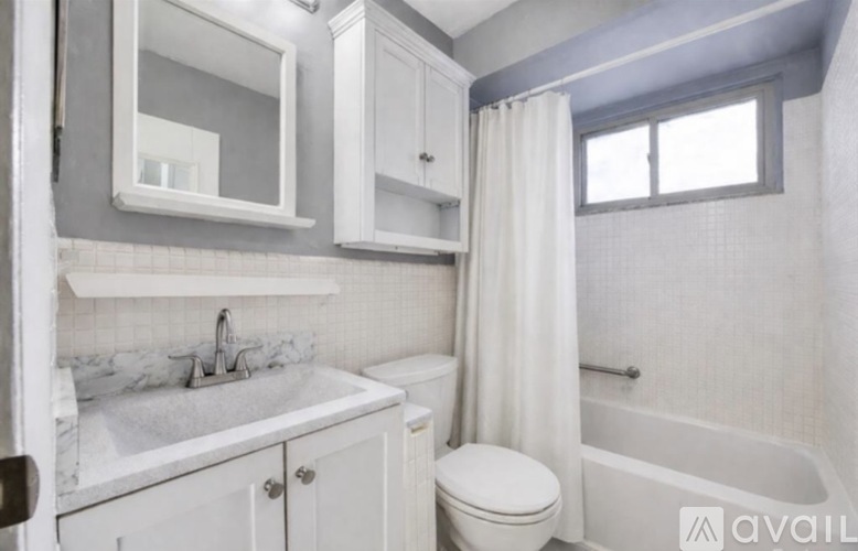 A white bathroom with a sink, toilet, and bathtub.