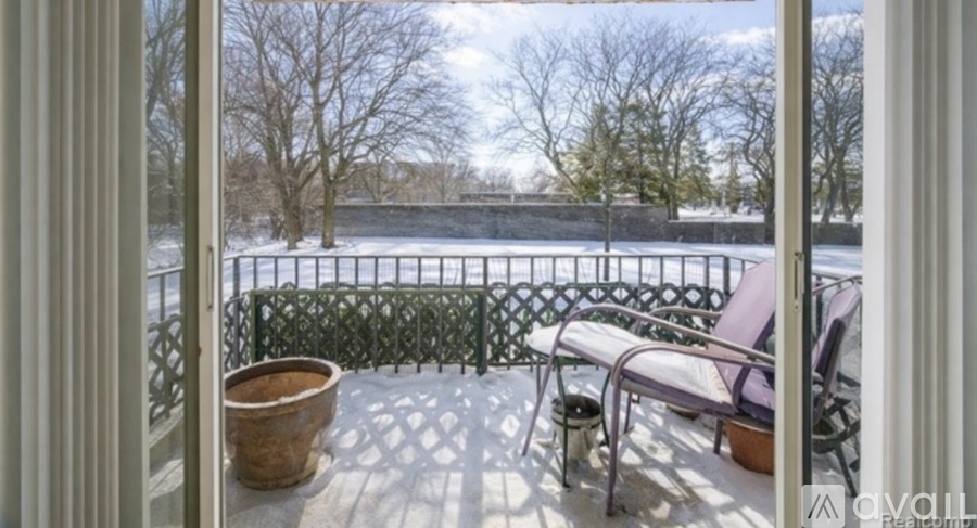 A balcony with a table and chairs overlooking a snowy landscape.