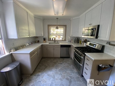 A kitchen with white cabinets and a tiled floor.