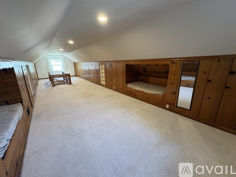 A spacious room with wooden walls and a carpeted floor.