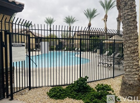 A pool surrounded by a black fence with a sign on it.