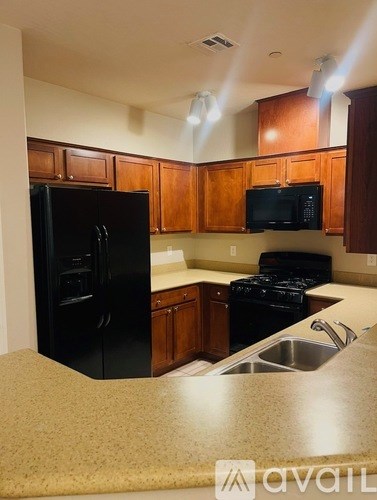A kitchen with black appliances and wooden cabinets.