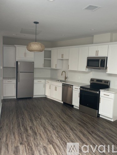A kitchen with white cabinets and a wooden floor.