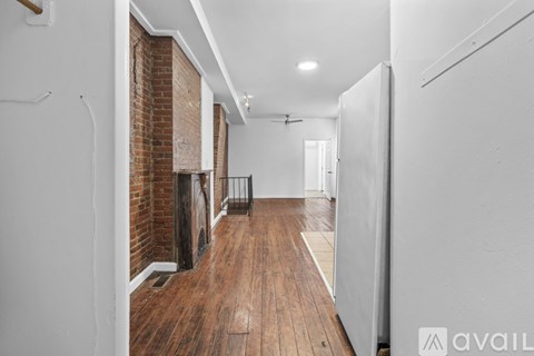 A long hallway with a brick wall on the left and a white wall on the right.