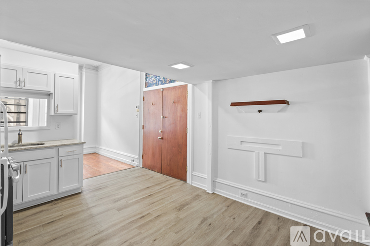 A kitchen with white cabinets and a wooden door.