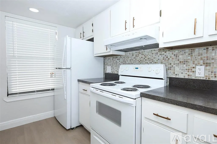 A kitchen with white appliances and cabinets.