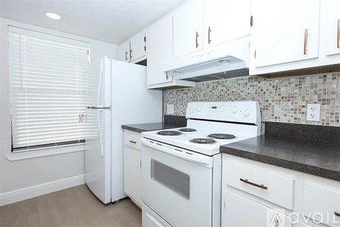 A kitchen with white appliances and cabinets.