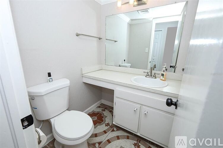 A white bathroom with a toilet, sink, and mirror.
