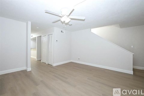 A spacious room with a ceiling fan and light fixture.