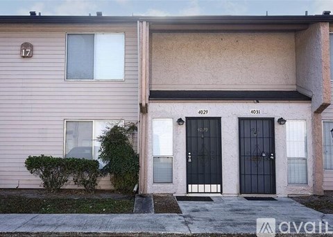 A two-story house with a beige exterior and black doors.