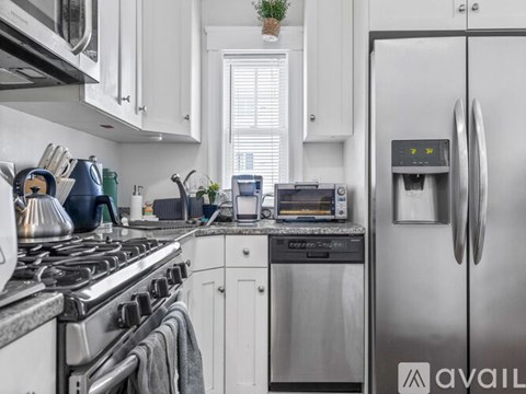 A modern kitchen with a stainless steel refrigerator and a stove top.
