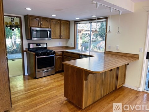 A kitchen with wooden cabinets and a large island.